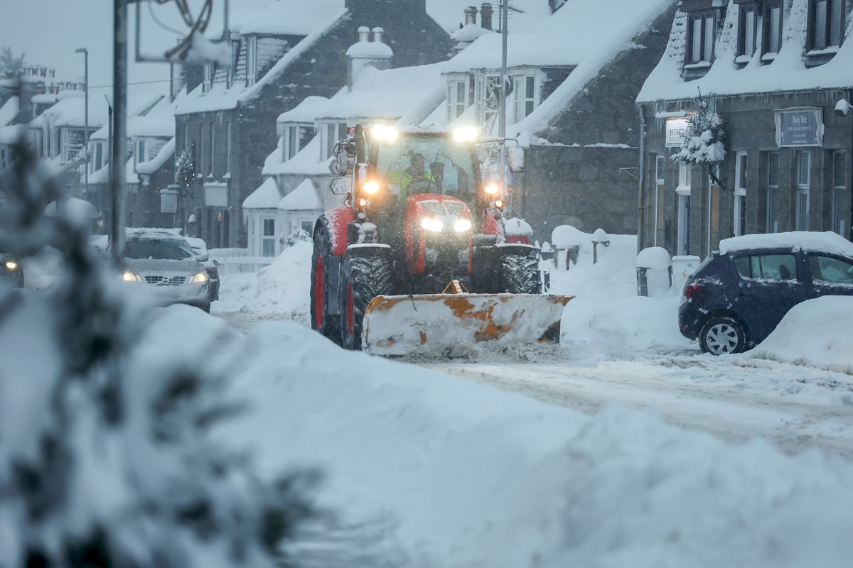 A snowplough clears the A944 