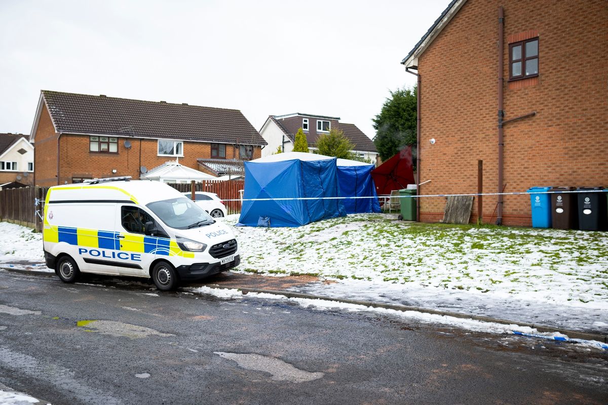 A police van parked next to the tape which surrounds the property