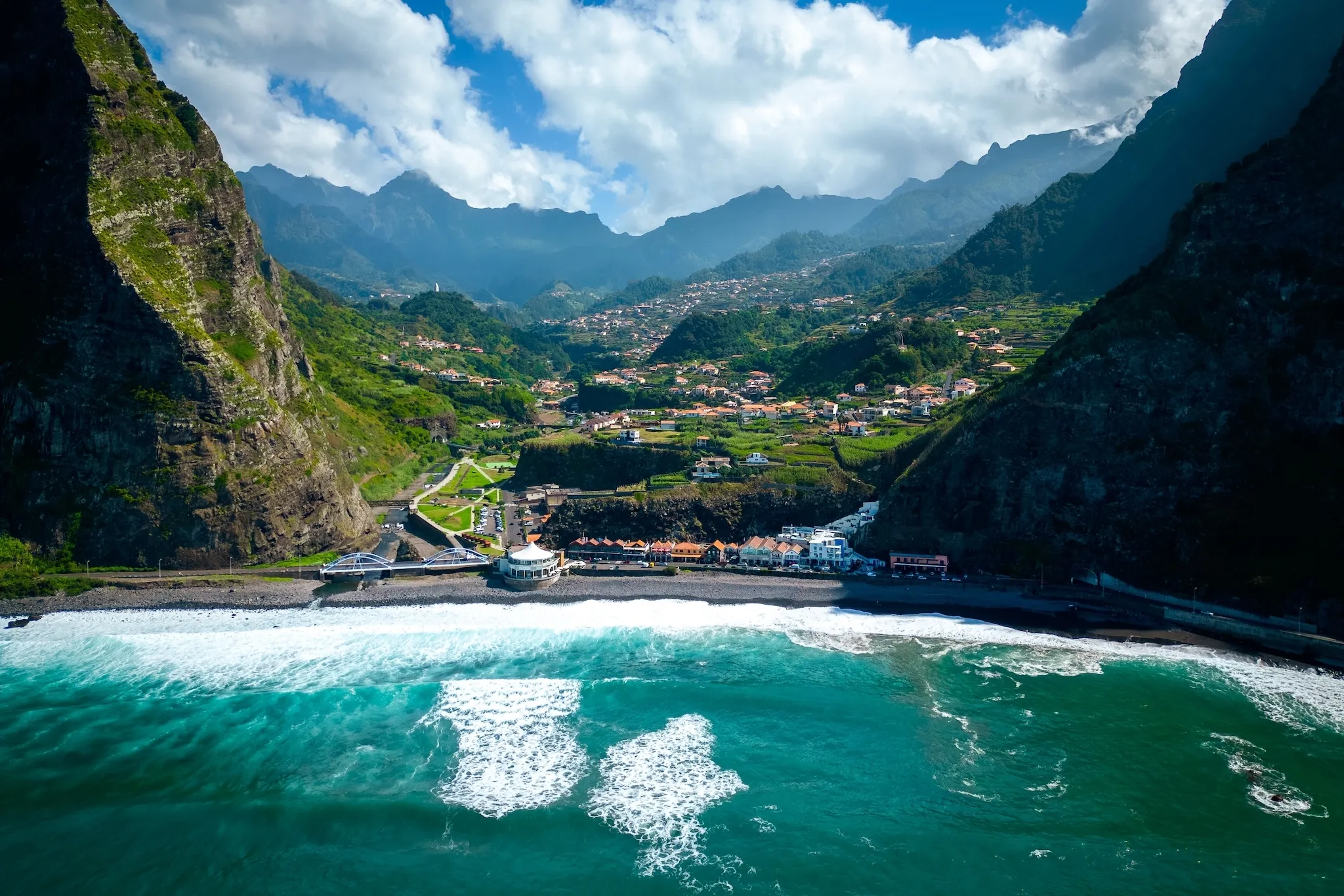 Fantastic aerial view of the coast at São Vicente, Madeira, Portugal, where the mighty waves crash on the black beach, surrounded on high mountains