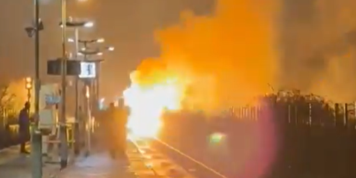 Flames erupt and black smoke fills night sky in huge blaze on train line