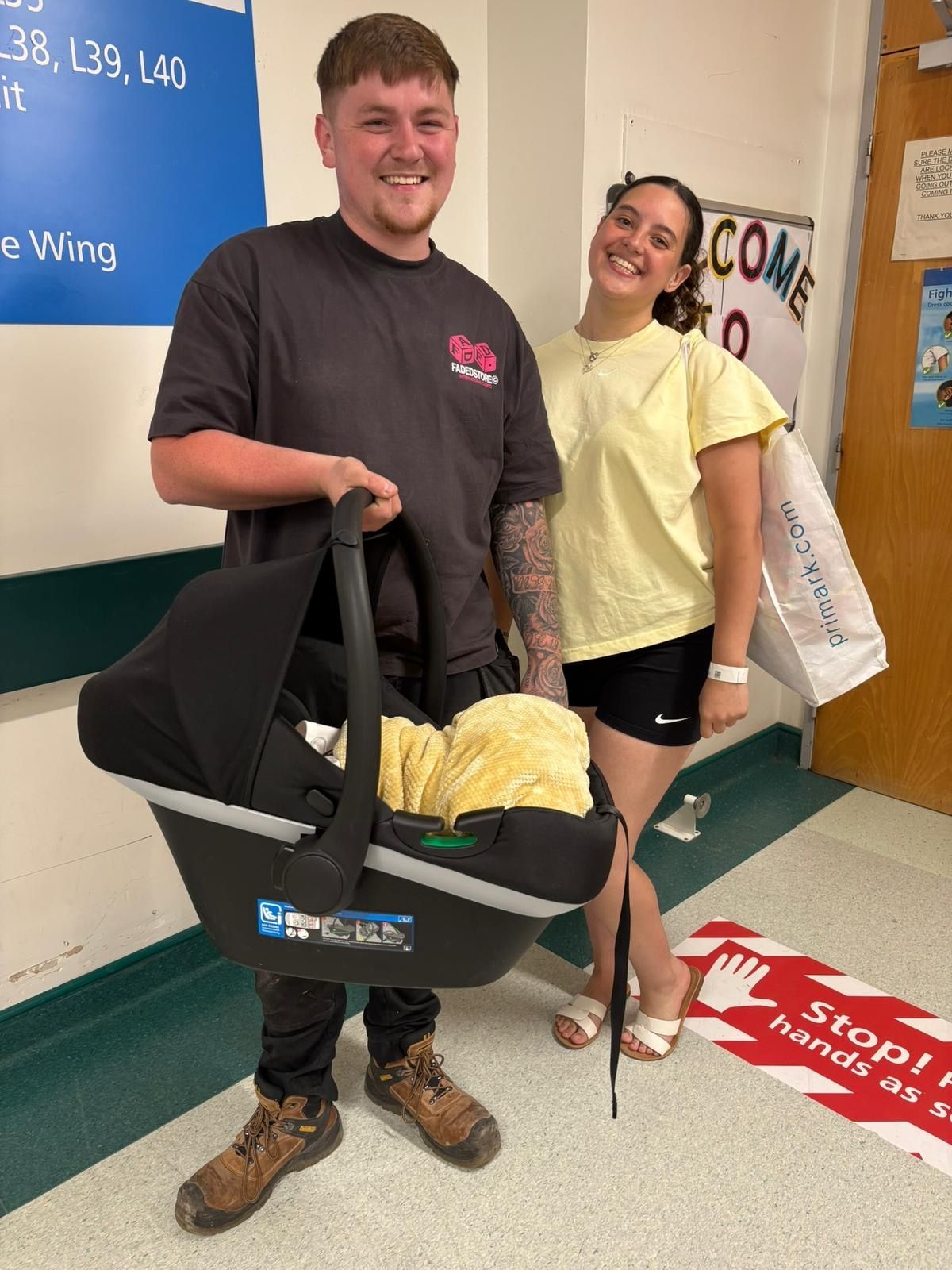 The couple leaving hospital with their new baby