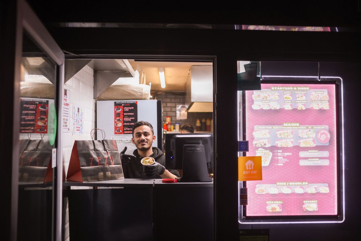 Rehan serving food from Zezu in the container village