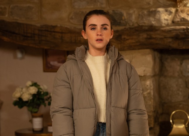 April stands looking worried in Emmerdale