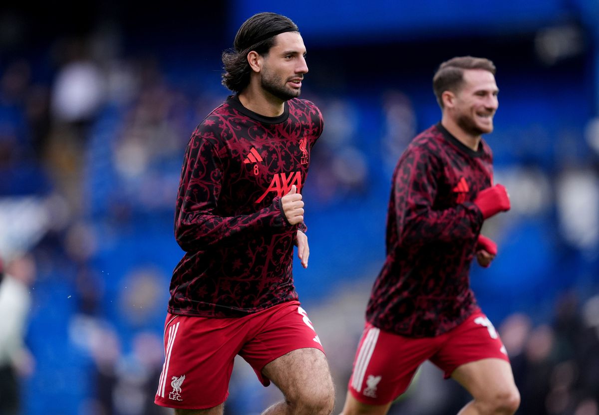 Dominik Szoboszlai and Alexis Mac Allister warm up in Liverpool training tops and home shorts.