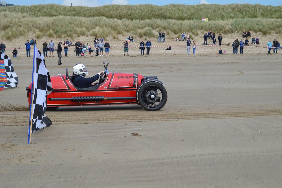 A three-wheeled car on a beach