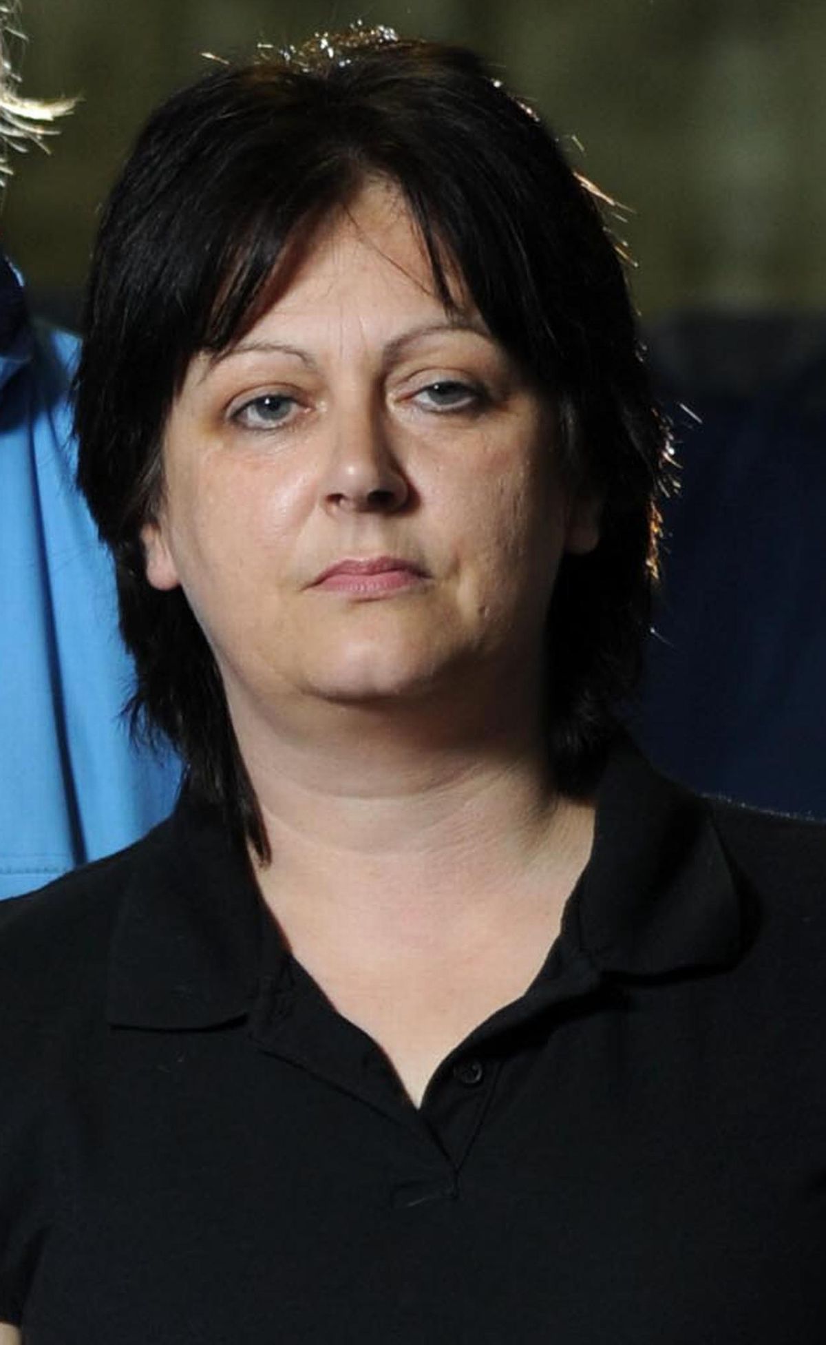 A while woman in her 40s with dark hair and wearing a black shirt