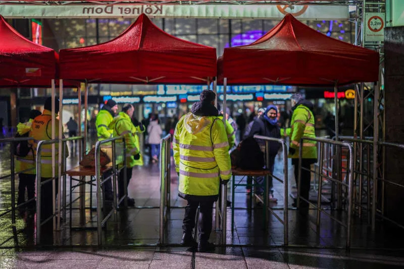 Security forces control an entrance to the protection zone around the Domplatte in Cologne, where carrying and setting off firecrackers and rockets is prohibited. Christoph Reichwein/dpa