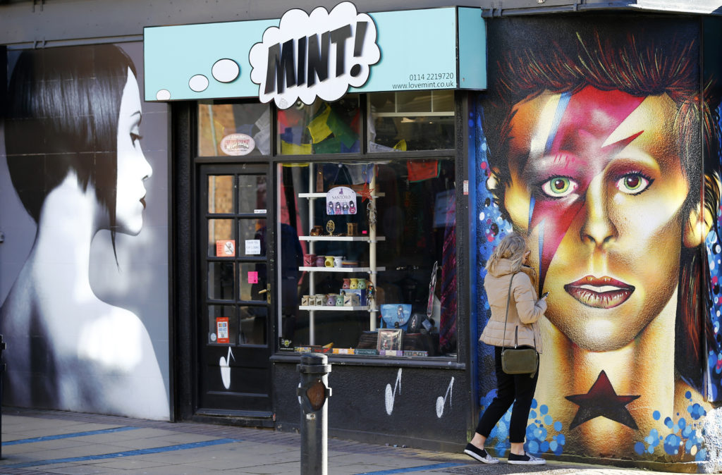 A woman touches a mural of David Bowie in Sheffield