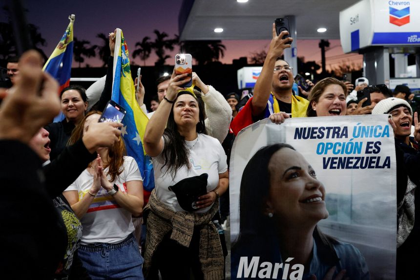 A woman holds a banner depicting Venezuelan opposition leader Maria Corina Machado in Doral, Florida, on January 3, 2026.