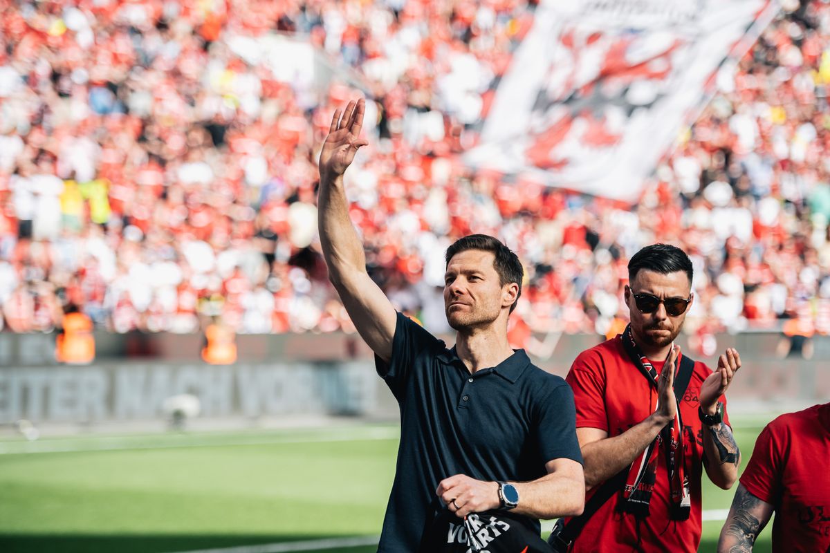 Xabi Alonso waves to Bayer Leverkusen fans.