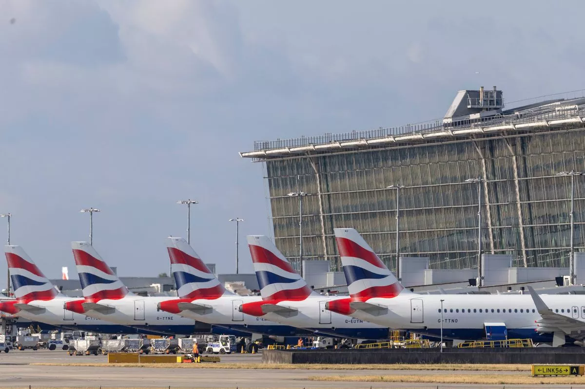 Passenger aircraft, operated by British Airways Plc, outside a terminal building at London Heathrow Airport Terminal 5, in London, UK, on Monday, July 14, 2025. London Heathrow Airport plans to invest £10 billion ($13.6 billion) over the next five years to upgrade its terminals and services after the dominant UK hub slipped in global airport rankings. Photographer: Jason Alden/Bloomberg via Getty Images