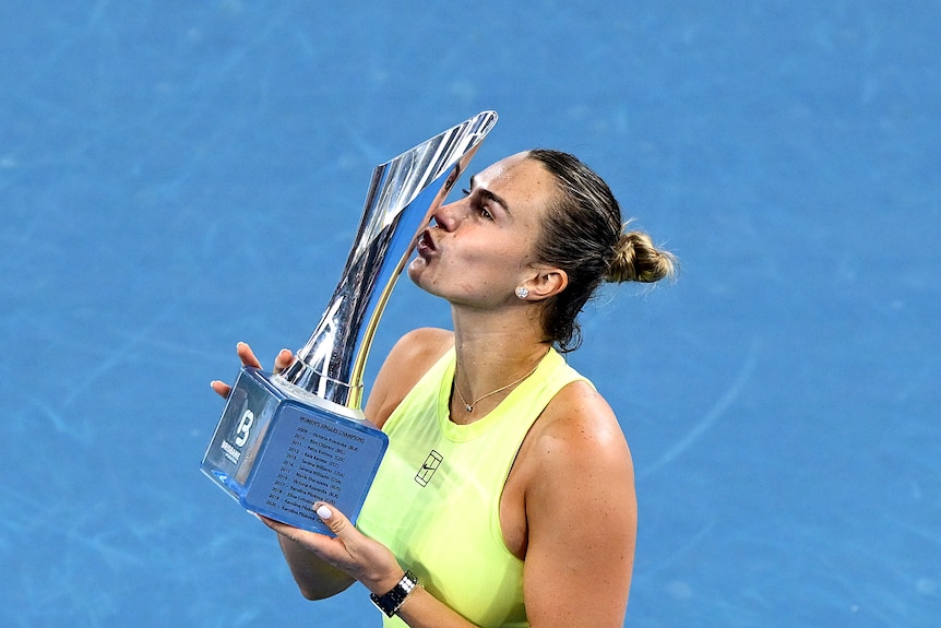 Aryna Sabalenka kisses a trophy