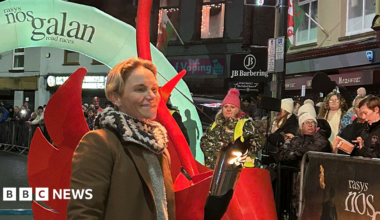 Jess Fishlock, pictured in the street of Mountain Ash town centre, holds a lit torch used to herald the start of the annual race