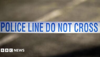 A white tape with the words police line do not cross written in blue.