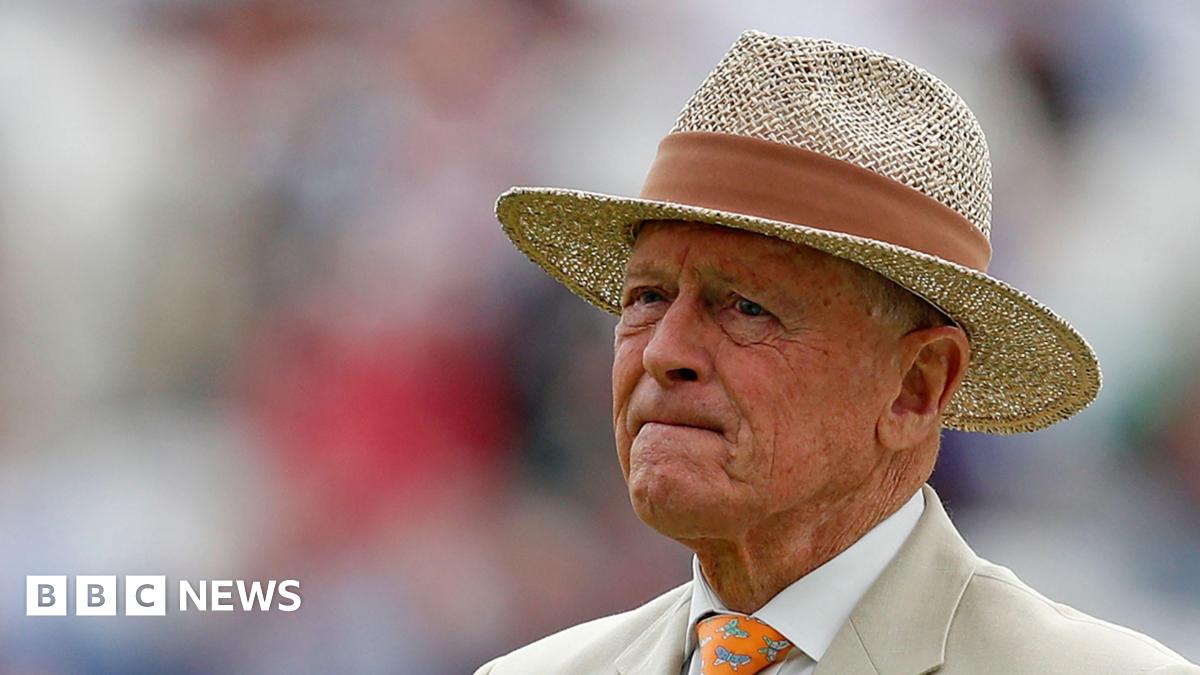 Sir Geoffrey Boycott, pictured wearing a boater hat and beige suit.