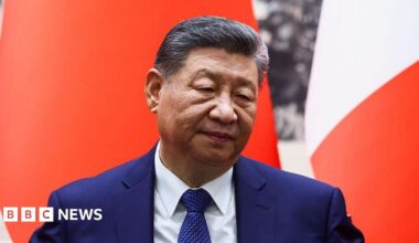 Chinese President Xi Jinping attends a signing ceremony for agreements at the Great Hall of the People in Beijing on December 4, 2025. He is wearing a dark blue sit and in front of a red and white background.