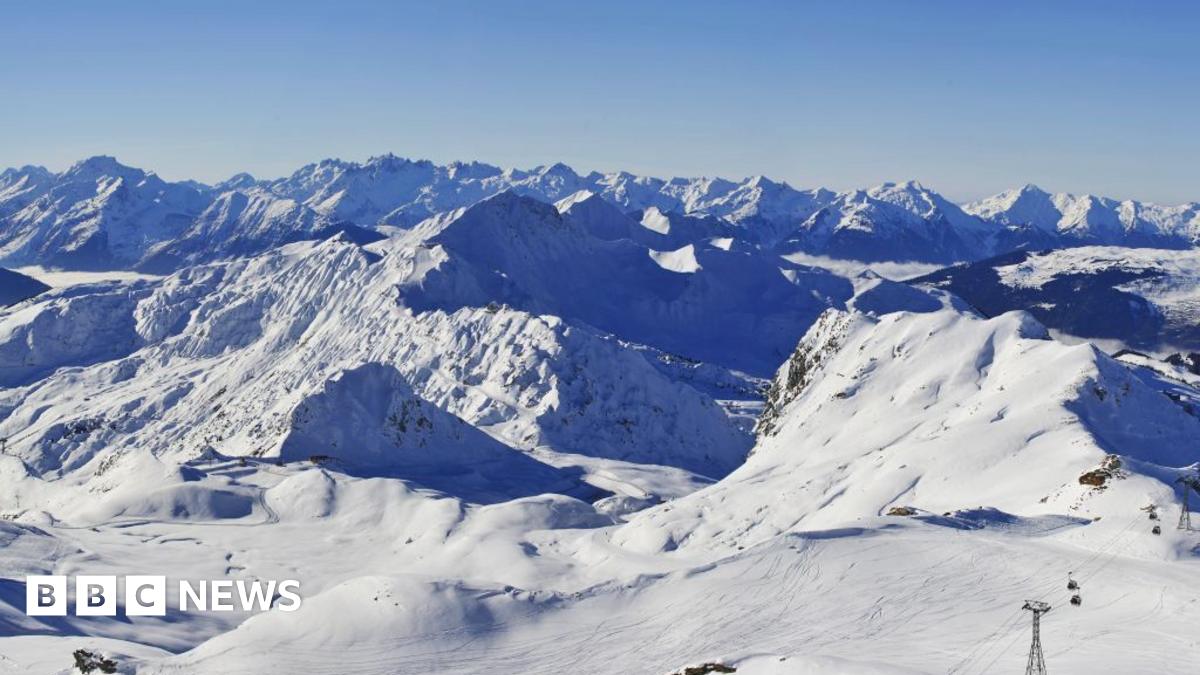 A white snowy mountainous landscape with a blue sky above is captured from the top of La Plagne ski resort in France.
