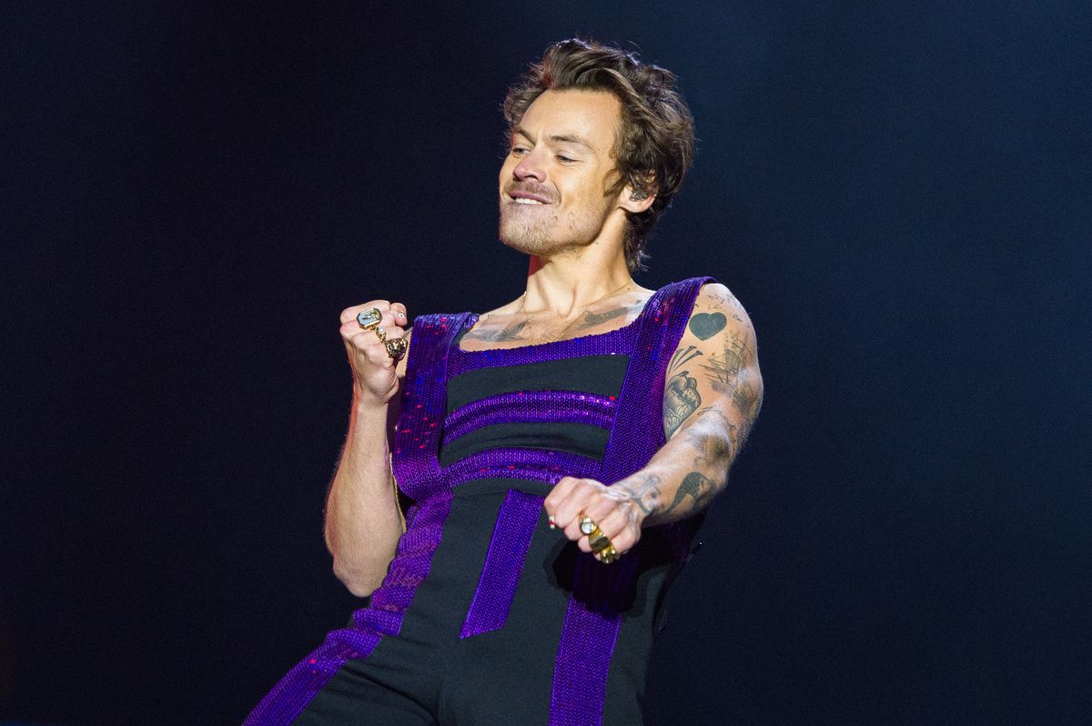 Harry Styles on stage in a purple outfit