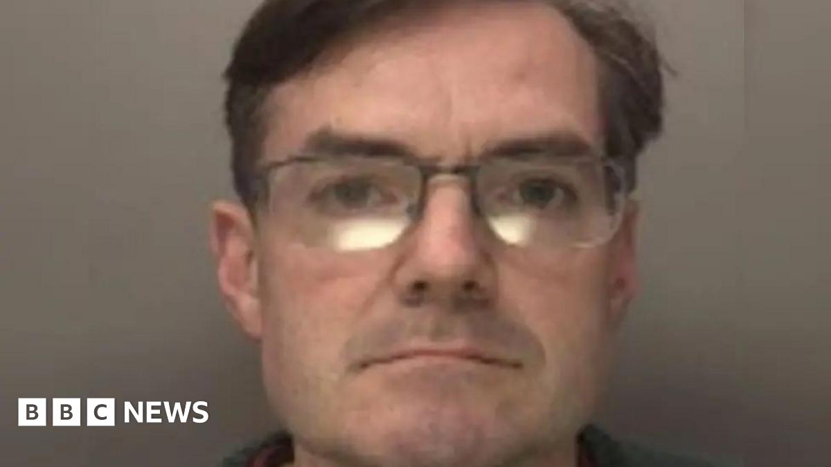 Peter Jenkins in a police mug-shot looks straight at the camera. He is wearing glasses and has short dark hair