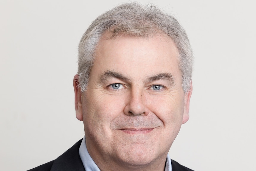 A headshot of a man smiling a the camera. 