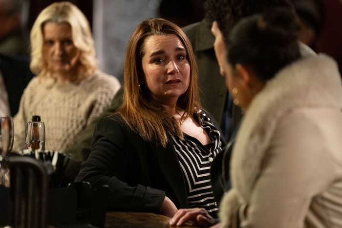 545926,TITLE:Eastenders Vicki stands shellshocked in the pub surrounded by Priya, Mark and Kathy in a scene from EastEnders
