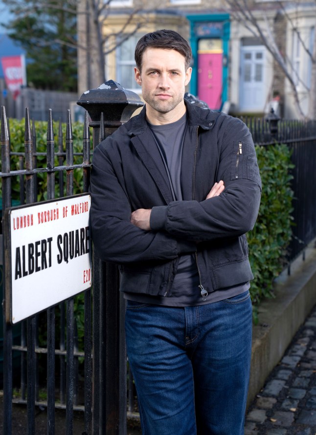 A promo image of Mark Fowler Jr, stood beside the Albert Square street sign