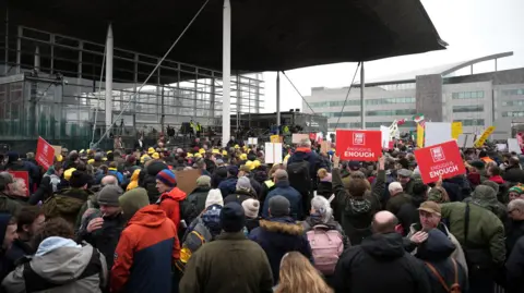 Getty Protesters holding placards gather outside the Senedd on February 28, 2024.