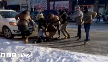 Federal agents are standing around a man on the ground