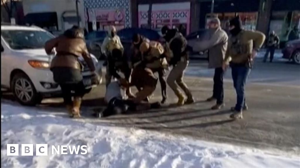 Federal agents are standing around a man on the ground