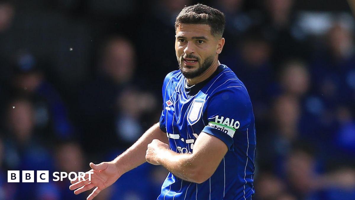 Sam Morsy holding his right arm out with his palm open during a match while playing for Ipswich