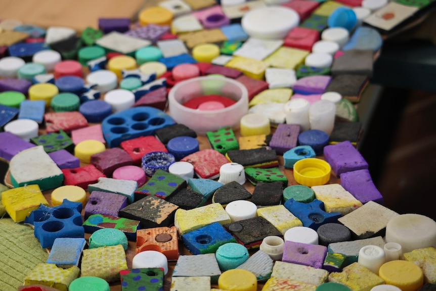 Multicoloured pieces of plastic and foam stuck on a surface.