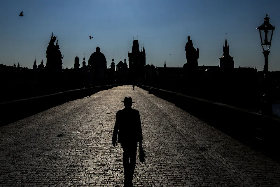 A man walks across the Charles Bridge early morning on April 28, 2021 in Prague.