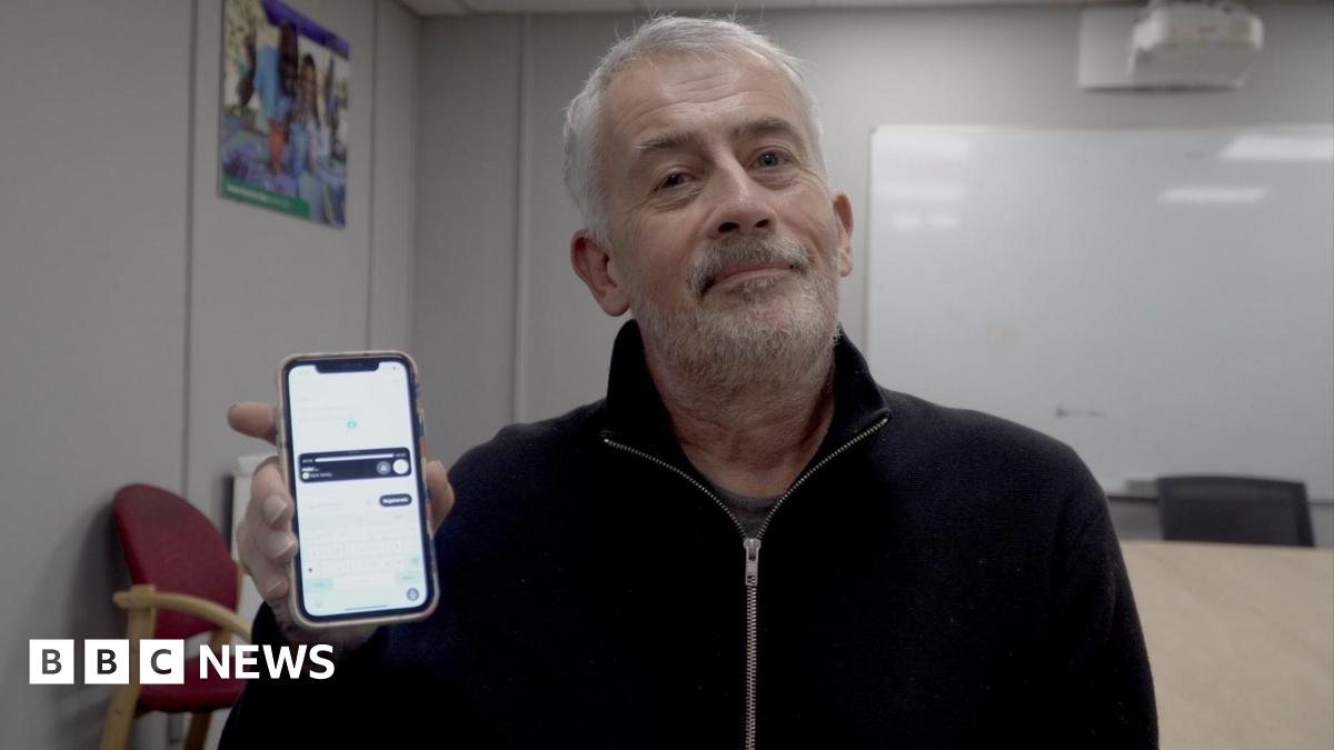 Donald Trump and Keir Starmer sit in a formal drawing room setting  on arm chairs with US and UK  flags behind them. Both have serious expressions and are looking out and not at each other.
