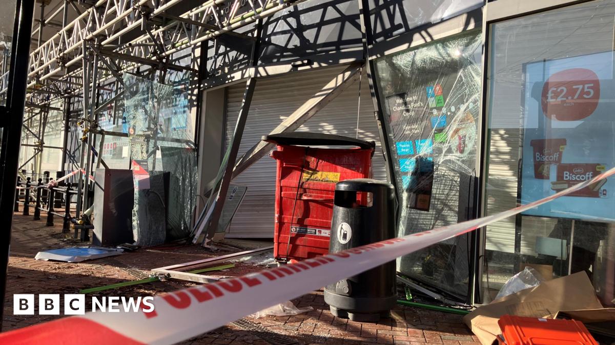 Police tape crosses a pavement outside a shuttered Co-op store, which also has scaffolding around it