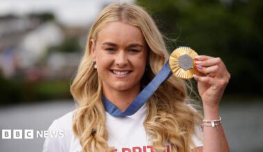 Hannah Scott displaying her Olympic gold medal, with blue ribbon attached