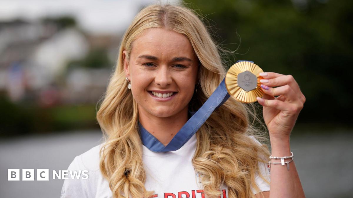 Hannah Scott displaying her Olympic gold medal, with blue ribbon attached