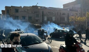 A cloud of tear gas floats across a road as cars and motorcycles pass through it, in Tehran (25/12/25)