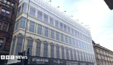 A facade showing Greek-style arches on the front of a tall building.
