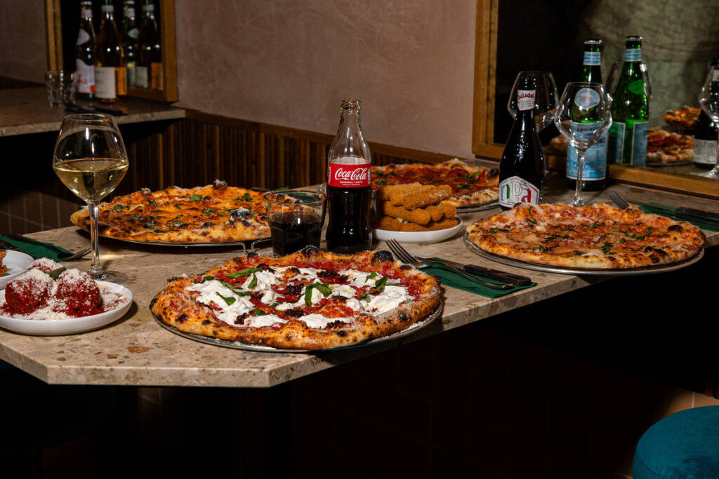 a table set with four different pizzas