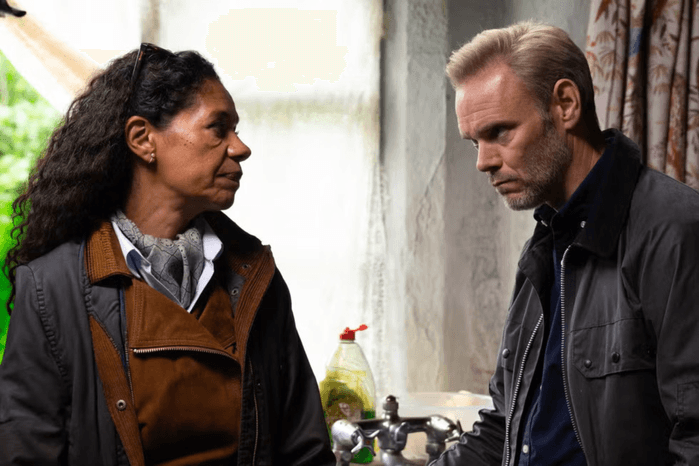 Celia looks towards Ray in a dirty kitchen in their farmhouse in Emmerdale