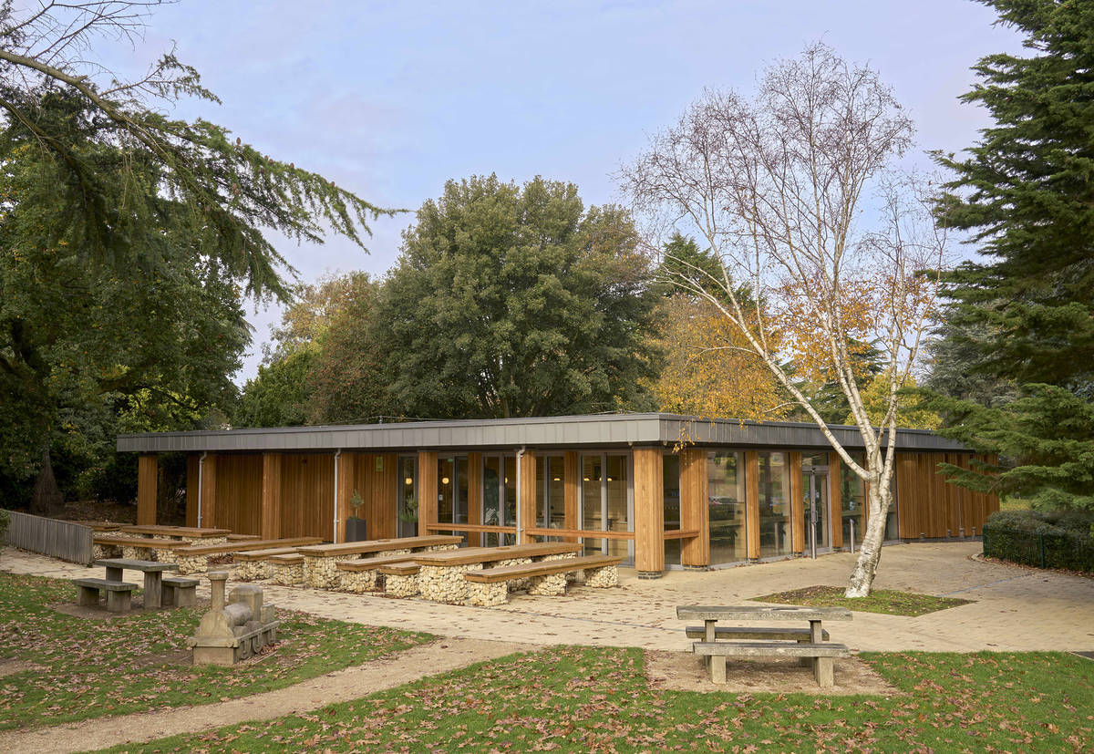 the exterior of a small cafe in the middle of a park, surrounded by trees