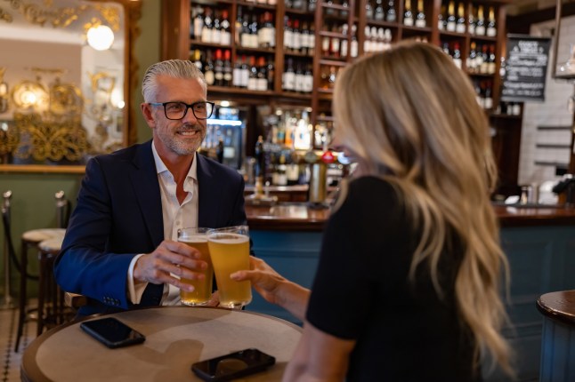Couple of business people having a drink at the pub after work