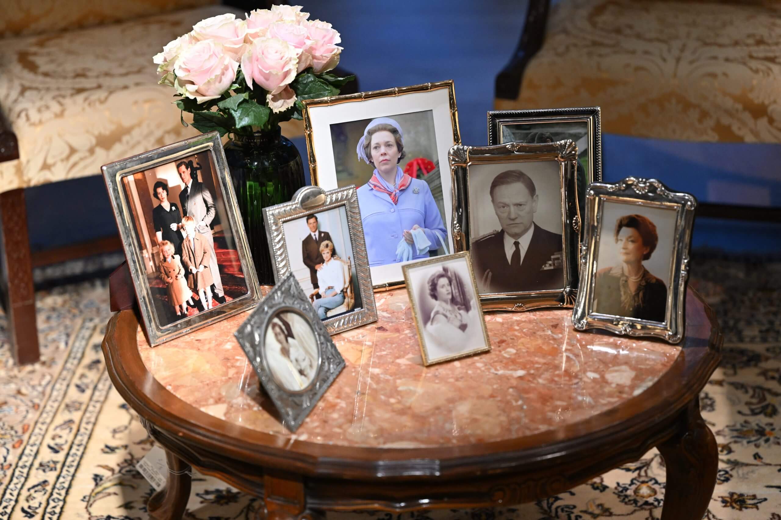 Framed photographs of actors, including Olivia Colman in her role as Queen Elizabeth II, from the Netflix series The Crown