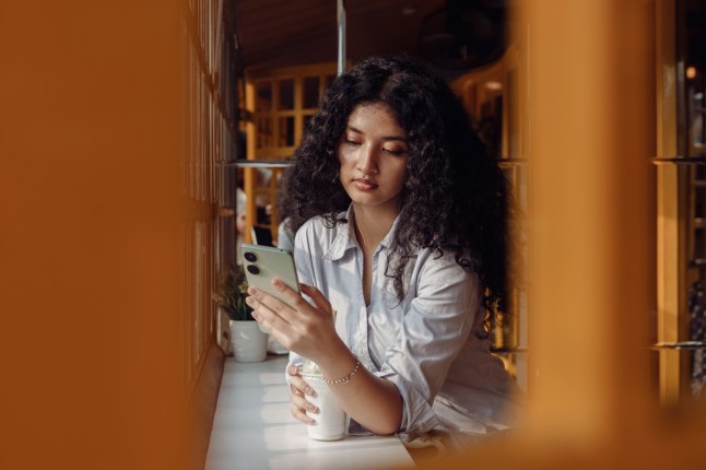 Young woman using a mobile phone to access her bank account.