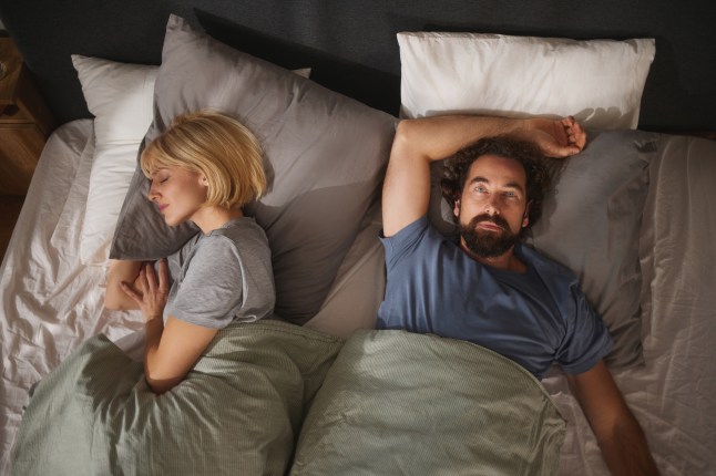Couple experiencing relationship problems lying in bed
