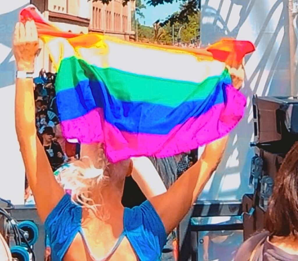 Lesbian waving the rainbow flag of the LGBT+ community during the Wetzlar Pride Parade in Germany in 2025 (Photo by @mmanoel2)