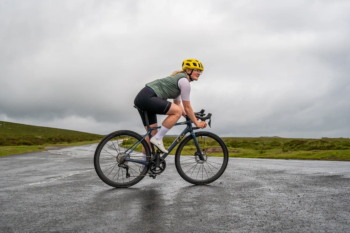 Female cyclist in green top riding the women's specific Liv Langma Advanced Pro 0 road bike