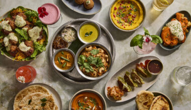 someone doing a pull up next to a bar, with someone holding a pint over their head as a tempting reward