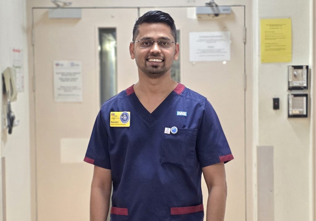 A nurse in a blue uniform in a hospital hallway
