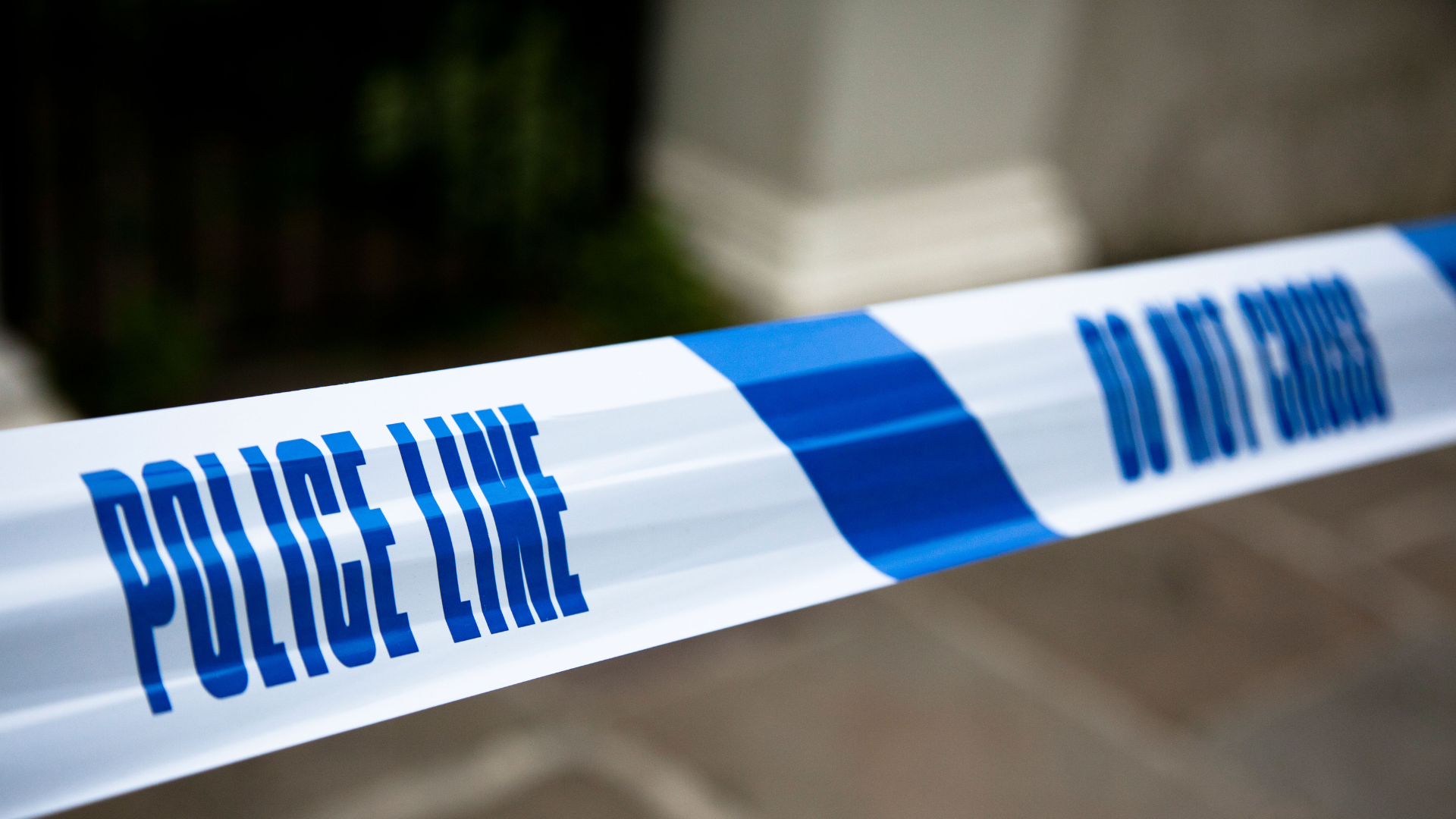 White and blue "POLICE LINE DO NOT CROSS" tape.